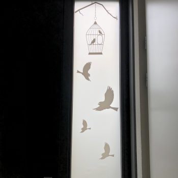 a window with birds and a cage