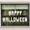 Happy Halloween pompoen raamsticker in druipende letters met twee pompoenkoppen op een raam