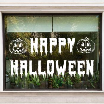 Happy Halloween pompoen raamsticker in druipende letters met twee pompoenkoppen op een raam
