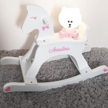 a white rocking horse with a teddy bear on it