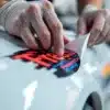 Handen brengen autosticker aan op glanzende autolak met professionele techniek, sticker gedeeltelijk afgepeld