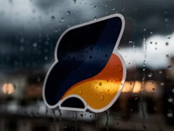 Weerbestendige vinylsticker op regenachtig glas met waterdruppels, warme binnenverlichting en onweerswolken op achtergrond
