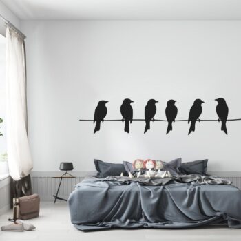 Muursticker vogeltjes op een draad boven het bed in de slaapkamer